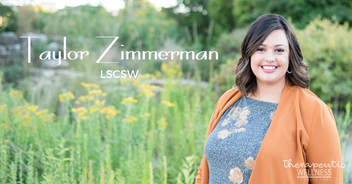 A woman with shoulder-length hair smiles while standing in front of greenery and flowers. Text on the image reads "Taylor Zimmerman, LSCSW" and "Therapeutic Wellness Counseling." Join Kali Harvey for holistic well-being transformations.