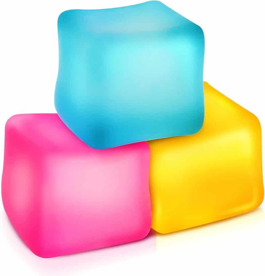 Three colorful ice cubes&mdash;one blue, one pink, and one yellow&mdash;stacked together on a white background. The cubes have a smooth, slightly rounded appearance.