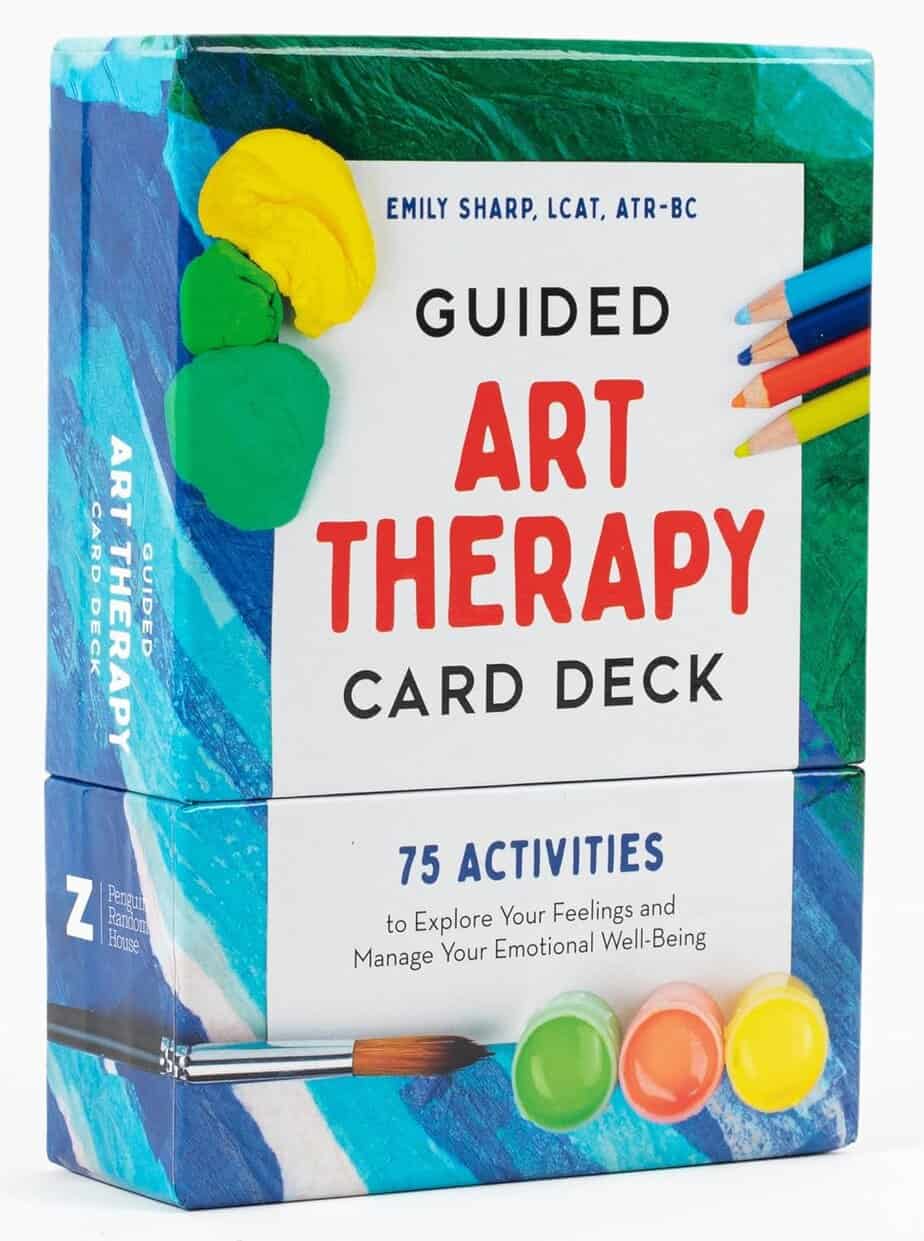 A box of "Guided Art Therapy Card Deck" by Emily Sharp with colored pencils and paint blobs on the cover. The box advertises 75 activities to explore feelings and manage emotional well-being.