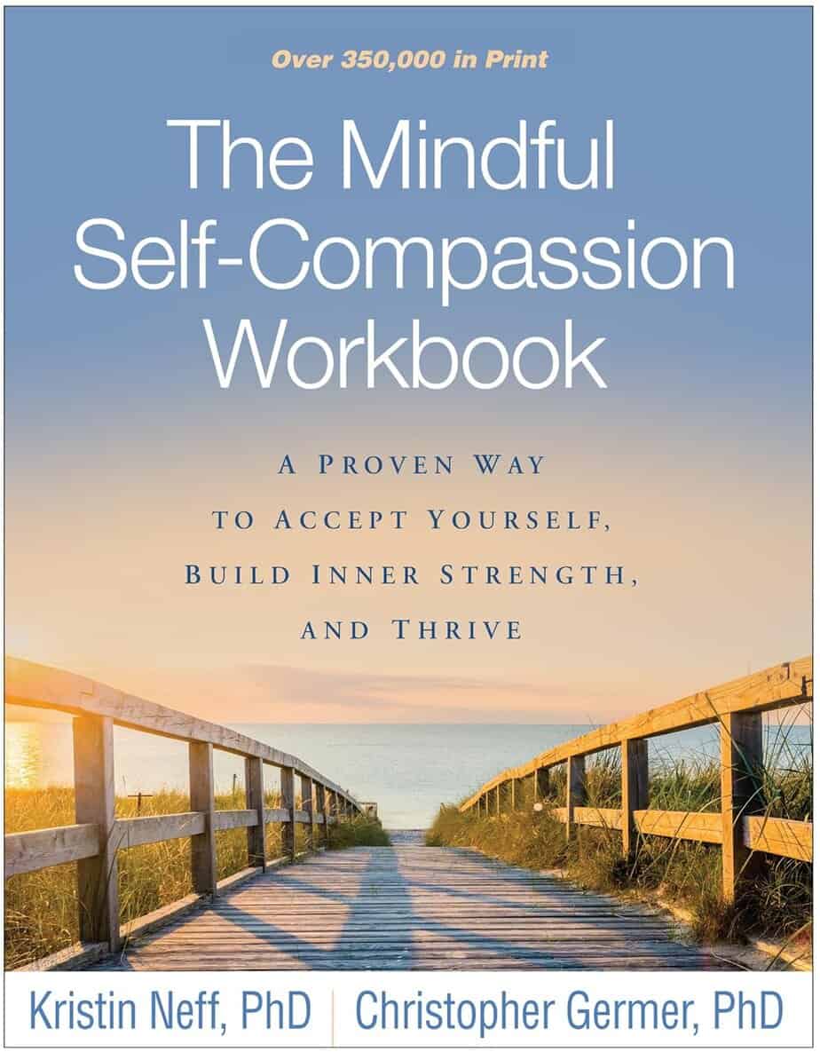 The cover of "The Mindful Self-Compassion Workbook" by Kristin Neff and Christopher Germer evokes the calming journey found in Gifts of Imperfection, with a wooden boardwalk leading to a beach under a pastel-colored sunset sky.