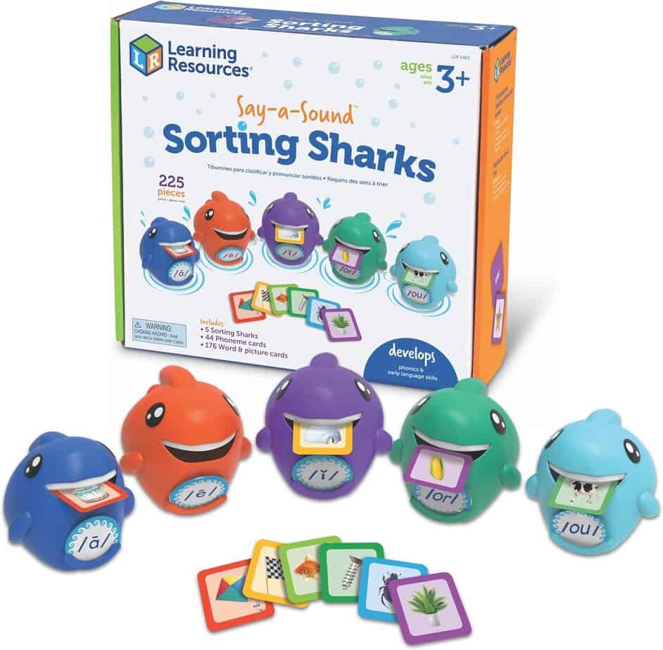 Four colorful toy sharks with word cards in their mouths are displayed in front of a &ldquo;Say-a-Sound Sorting Sharks&rdquo; box by Learning Resources, a fun sorting toy set for children ages 3 and up. Word and picture cards are spread in front.