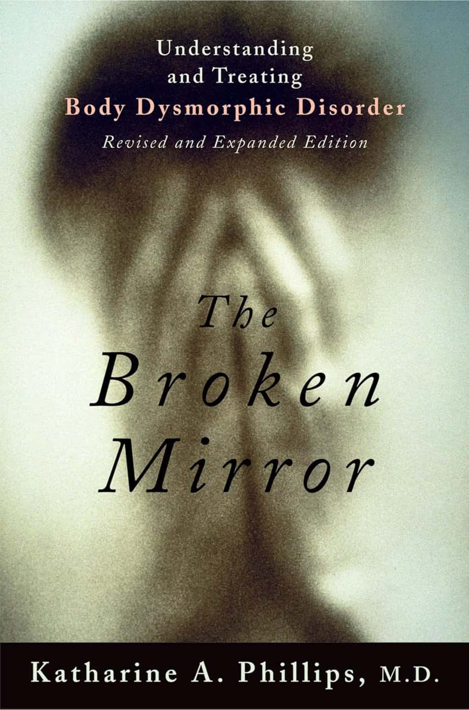 Book cover for "The Broken Mirror" by Katharine A. Phillips, M.D., showing a blurred, distressed figure holding their face, with a subtitle about understanding and treating Body Dysmorphic Disorder.